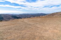 an open mountain with dirt roads leading into the mountains and a wide view of the landscape