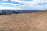 an open mountain with dirt roads leading into the mountains and a wide view of the landscape