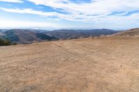 an open mountain with dirt roads leading into the mountains and a wide view of the landscape