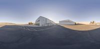 the reflection of an open parking lot showing a building and hangar for a team of employees