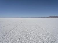 the vast open plain on a clear day with snow on the ground and mountains in the background