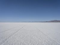 the vast open plain on a clear day with snow on the ground and mountains in the background