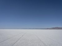 the vast open plain on a clear day with snow on the ground and mountains in the background