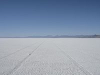 the vast open plain on a clear day with snow on the ground and mountains in the background