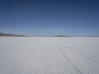 the vast open plain on a clear day with snow on the ground and mountains in the background