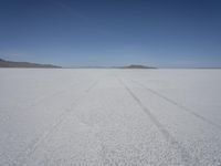 the vast open plain on a clear day with snow on the ground and mountains in the background