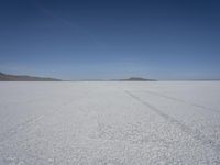 the vast open plain on a clear day with snow on the ground and mountains in the background