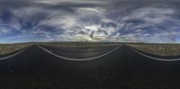 an open road with two lanes extending into the horizon, with clouds hovering from top