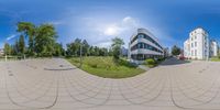 a fish eye lens with two buildings in the background and one is on the ground