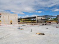 a large open space that includes an arena like building with a concrete slab on the ground