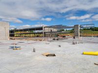 a large open space that includes an arena like building with a concrete slab on the ground