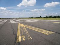 the street is paved with yellow lines that make it difficult to cross the runway for pedestrians