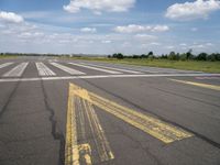 the street is paved with yellow lines that make it difficult to cross the runway for pedestrians