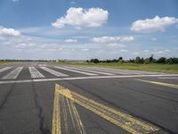 the street is paved with yellow lines that make it difficult to cross the runway for pedestrians