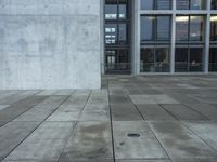 a building with windows and a floor made out of concrete has tile floors in front of it