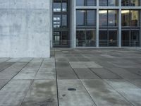 a building with windows and a floor made out of concrete has tile floors in front of it