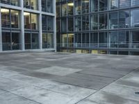 a building with windows and a floor made out of concrete has tile floors in front of it