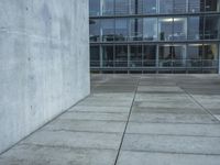 a building with windows and a floor made out of concrete has tile floors in front of it