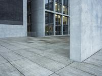 a building with windows and a floor made out of concrete has tile floors in front of it