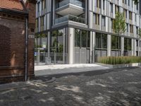 modern glass office building on brick streets corner with stairs leading up and a brick block walkway