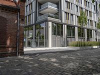 modern glass office building on brick streets corner with stairs leading up and a brick block walkway