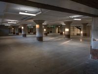 an empty office with columns and light coming in from them, with some lights on