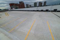 a large roof that has some yellow lines on it, in front of a skyline