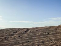 a person is riding their surfboard on the sand dunes in the desert of a mountain