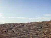 a person is riding their surfboard on the sand dunes in the desert of a mountain