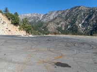 a road with yellow chalk written in the middle of it and a mountain in the back ground