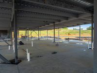 empty industrial space with some steel pipes and workers working on the floor area of it