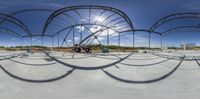 a man riding a bicycle through a metal structure with an empty track in the foreground