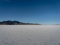 desert scenery including mountains, clouds and blue sky in the background on clear day at a salt flat area