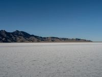 desert scenery including mountains, clouds and blue sky in the background on clear day at a salt flat area