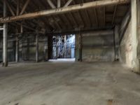 an empty industrial warehouse with exposed beams and large windows in the space outside on a sunny day