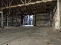 an empty industrial warehouse with exposed beams and large windows in the space outside on a sunny day