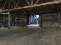 an empty industrial warehouse with exposed beams and large windows in the space outside on a sunny day