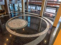 a circular floor in an office building with people passing by looking out the window of it