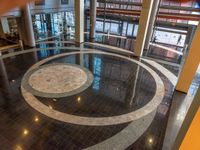 a circular floor in an office building with people passing by looking out the window of it