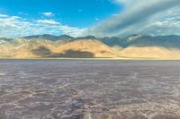 a large dry lake in the middle of the desert with mountains in the distance,