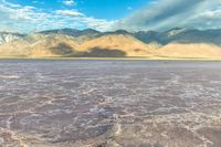 a large dry lake in the middle of the desert with mountains in the distance,