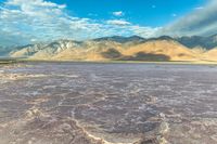 a large dry lake in the middle of the desert with mountains in the distance,