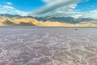 a large dry lake in the middle of the desert with mountains in the distance,