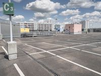 an empty parking lot with a large building in the back ground and a building behind it