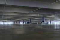 an empty parking garage with some signs hanging off the ceiling of it's sides