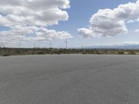 several windmills can be seen in the background as well as a paved road in the foreground