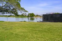 an open space with a small pond on one side, and a concrete structure on the other