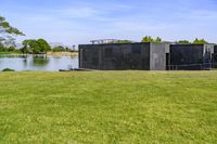 an open space with a small pond on one side, and a concrete structure on the other