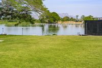 an open space with a small pond on one side, and a concrete structure on the other