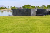 an open space with a small pond on one side, and a concrete structure on the other